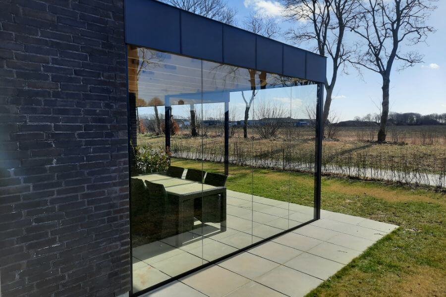 Glasvæg monteret som vindafskærmning ved overdækket terrasse
